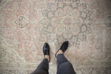 Distressed Turkish Oushak rug, faded blush, ivory, charcoal ornate floral design.