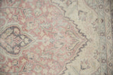 Distressed Oushak carpet texture showing faded blush, sea foam green, charcoal, and ivory.