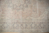 Decorative distressed Oushak carpet field and border with faded blush, charcoal, and ivory tones.