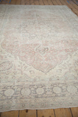Distressed Oushak carpet with faded dusty blush, ivory, and charcoal ornate floral patterns.