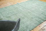 Airy distressed pile texture in faded green tones on a vintage Oushak rug.