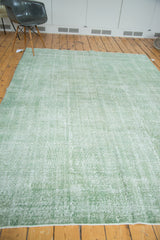 Distressed faded green pile and texture of a vintage hand-knotted Oushak rug.