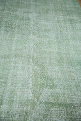 Faded green tones and distressed texture of this vintage hand knotted Oushak pile.