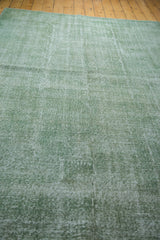 Faded green vintage Oushak rug showing subtle distressed texture.