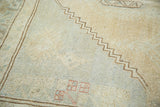 Distressed Oushak rug pile with subtle beige, pale green, and a dark brown zig-zag pattern.