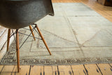 Geometric motifs of dark brown border framing subtle earth tone abrashes on distressed Oushak.