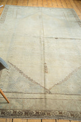 Distressed Turkish Oushak rug corner, featuring subtle beige pile, geometric outlines, and soft earth tone abrashes.