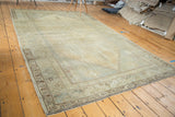 Distressed Oushak carpet, earth toned, showing subtle medallion and muted outlines from abrashes.