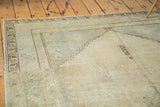 Faded outlines and distressed texture of a vintage beige Oushak carpet.