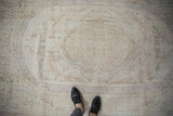 Distressed Oushak carpet showing muted Aubosson-style patterns in blush rose and ivory.