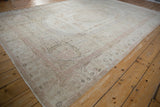 Distressed Oushak carpet with faded Aubosson-style patterns in blush, ivory, and powder blue.
