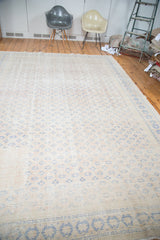 Faded apricot and royal blue geometric patterns on a distressed Oushak carpet.
