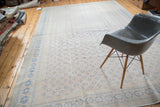 Faded apricot field with repeating royal blue motifs on a distressed Oushak rug.