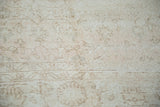Distressed Oushak carpet pile with faded floral patterns in light beige and tan.