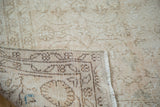Distressed tan floral pattern and hand knotted reverse of vintage Oushak rug.