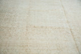 Distressed texture of the Oushak rug's muted floral design in light beige and ivory.
