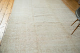 Distressed Oushak carpet with faded allover floral motifs in neutral beige tones.