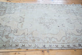 Distressed vintage Oushak rug, faded ivory and seafoam, bold charcoal outlined medallion.