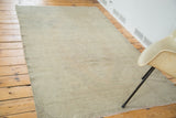Distressed Oushak rug with textured aesthetic and nuanced neutral tones.