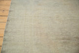 Angled view of a distressed Oushak rug's textured pile with neutral silver, grey tones.
