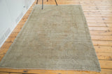Neutral silver-grey distressed pile and short fringe on the Oushak rug.
