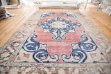 Distressed Oushak carpet, faded red field, dark blue curvilinear medallion, and unique parallel weave.