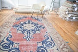 Uniquely drawn star medallion with scrolling arabesques on a distressed cherry red Oushak rug.