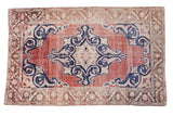 Distressed vintage Oushak rug in faded cherry red with a bold navy medallion, 6' x 9'4