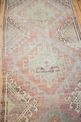 Distressed Oushak runner detail with faded cinnabar red and soft sea foam hook gul patterns.