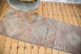 Distressed Turkish Oushak runner with faded cinnabar and soft sea foam rectilinear patterns.