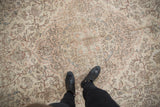 Underfoot view of distressed Oushak carpet with faded ivory, blush, and blue traditional design.