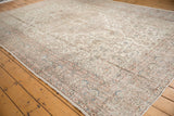 Distressed vintage Oushak rug corner featuring faded ivory, blush rose, and powder blue patterns.