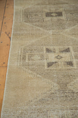 Textured distressed Oushak rug with geometric tribal motifs in beige gold and charcoal.