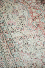 Distressed Oushak carpet showing intricate patterns in blush rose, celadon, ivory.