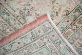 Distressed Oushak pile and folded geometric border in celadon, blush, ivory.