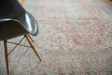 Distressed blush rose and celadon border detail of the ornate Oushak carpet.