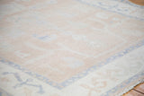 Distressed Oushak carpet with faded apricot, dusty blush field and primitive sky blue border.
