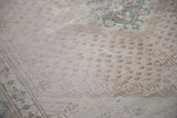 Distressed Oushak carpet showing expressive cloudband designs and diminutive botehs.