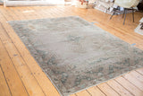 Distressed Oushak carpet end panel, unique elongated cloudband designs in soft forest green and silver.
