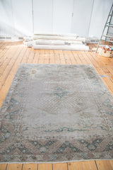 Distressed hand-knotted Oushak carpet with quatrefoil medallion and cloudband designs in silver, green.