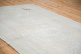 Distressed Oushak texture with faded apricot peach, silver, and exposed foundation.