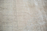 Distressed Oushak rug's exposed foundation texture in faded apricot peach and grey.