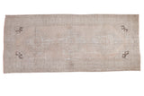 Distressed Oushak runner with triple medallion and corner spandrels in faded apricot and charcoal.