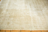 Distressed Oushak rug with muted ivory and beige worn texture, revealing subtle design.