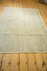 Frayed edge and worn texture of the distressed Oushak rug, showing muted tones.