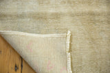 Hand knotted foundation and distressed pile of this Oushak rug, showing ivory and beige.