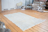 Distressed Turkish Oushak rug with faded medallion and soft ivory, beige colors.