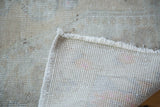 Distressed neutral pile and tight hand-knotted foundation of a vintage Turkish Oushak rug.