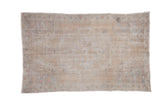 Distressed Oushak rug with faded medallion, powder pearl border, and muted beige and pink.