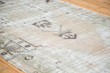 Distressed vintage Oushak runner pile featuring faded apricot, moss green, geometric motifs.